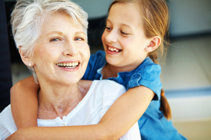 A young girl hugging her grandmother happily - Copyspace