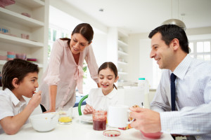 Family Having Breakfast Before Husband Goes To Work